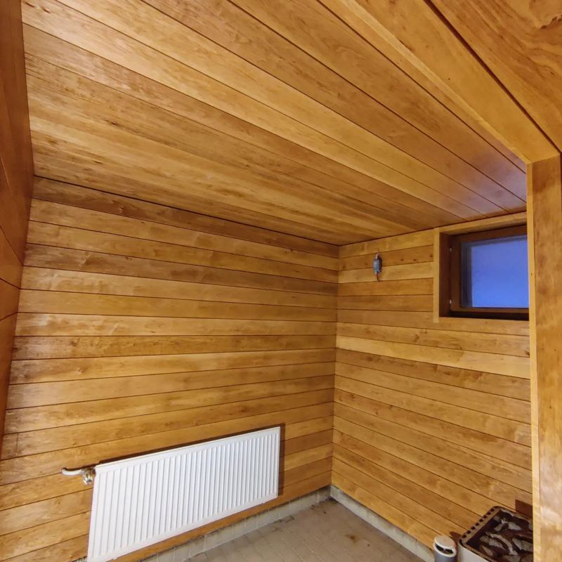 Sauna, jonka seinät ja katto on paneloitu tervalepällä